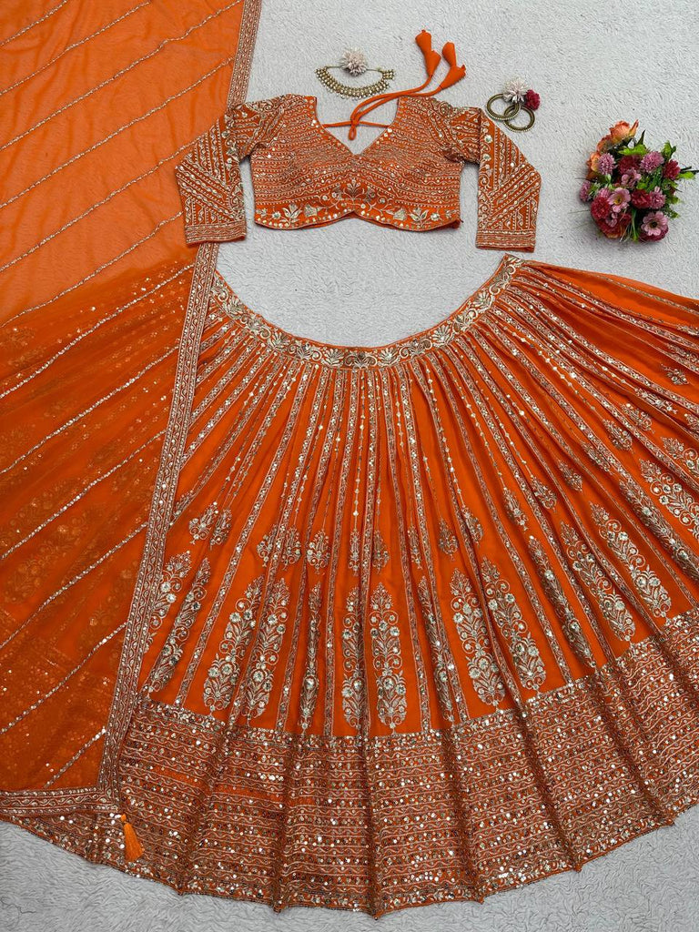 Orange embroidered lehenga laid flat on a carpet — blouse, skirt and dupatta with jewellery: the boutique's phone photo
