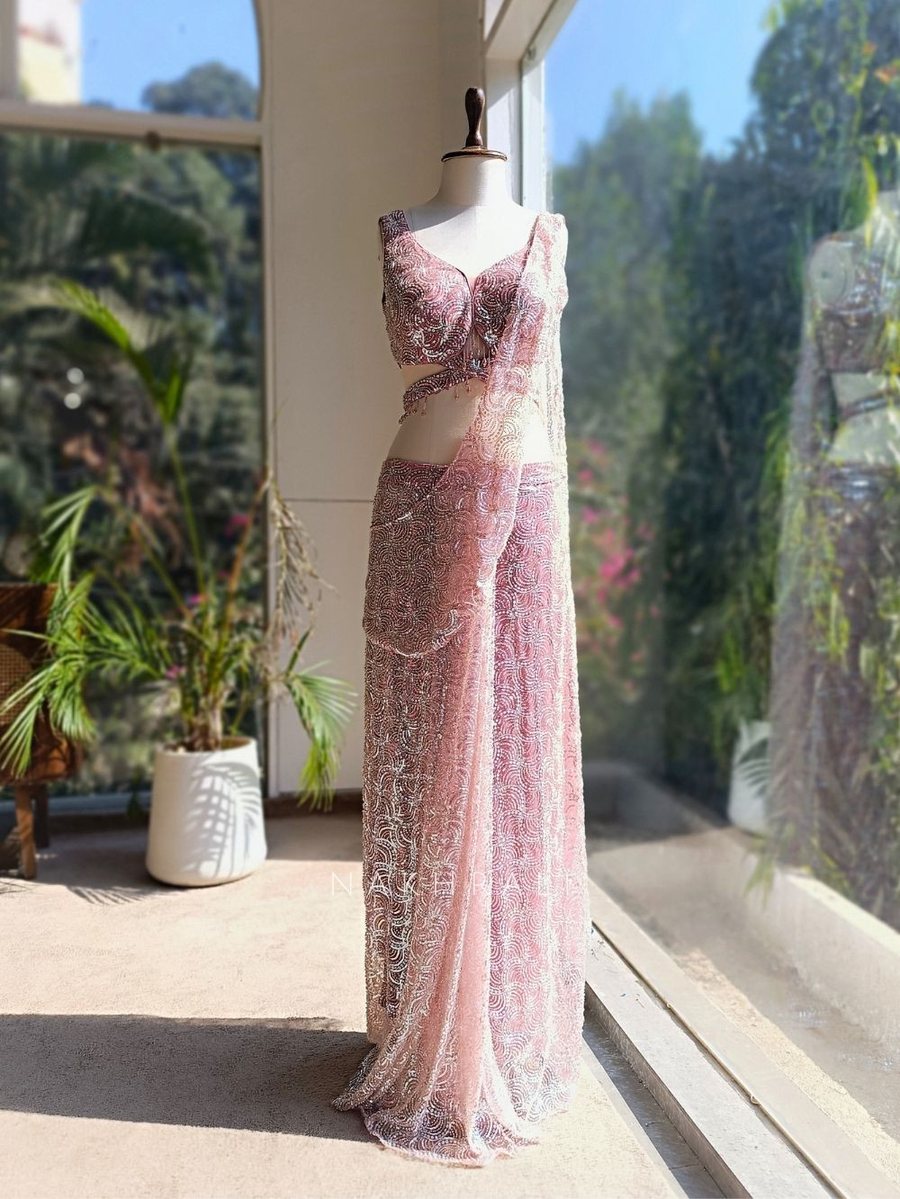 Heavily sequinned saree on a dress form — the boutique's original photo